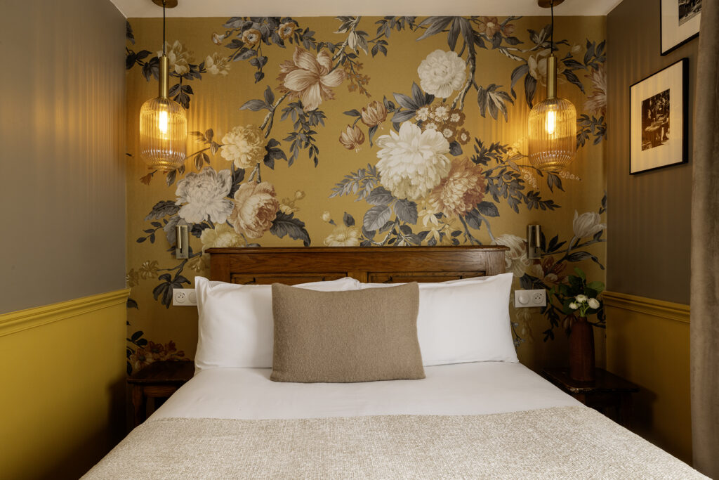 Pâques à Paris : chambre d'hôtel avec lit double, papier peint jaune à fleurs et lumières | welcome hotel paris