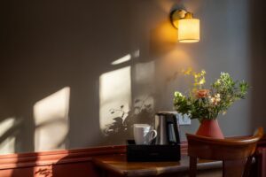 Quarto twin no Welcome Hotel Paris com um vaso de flores e xícaras de café sobre a mesa.