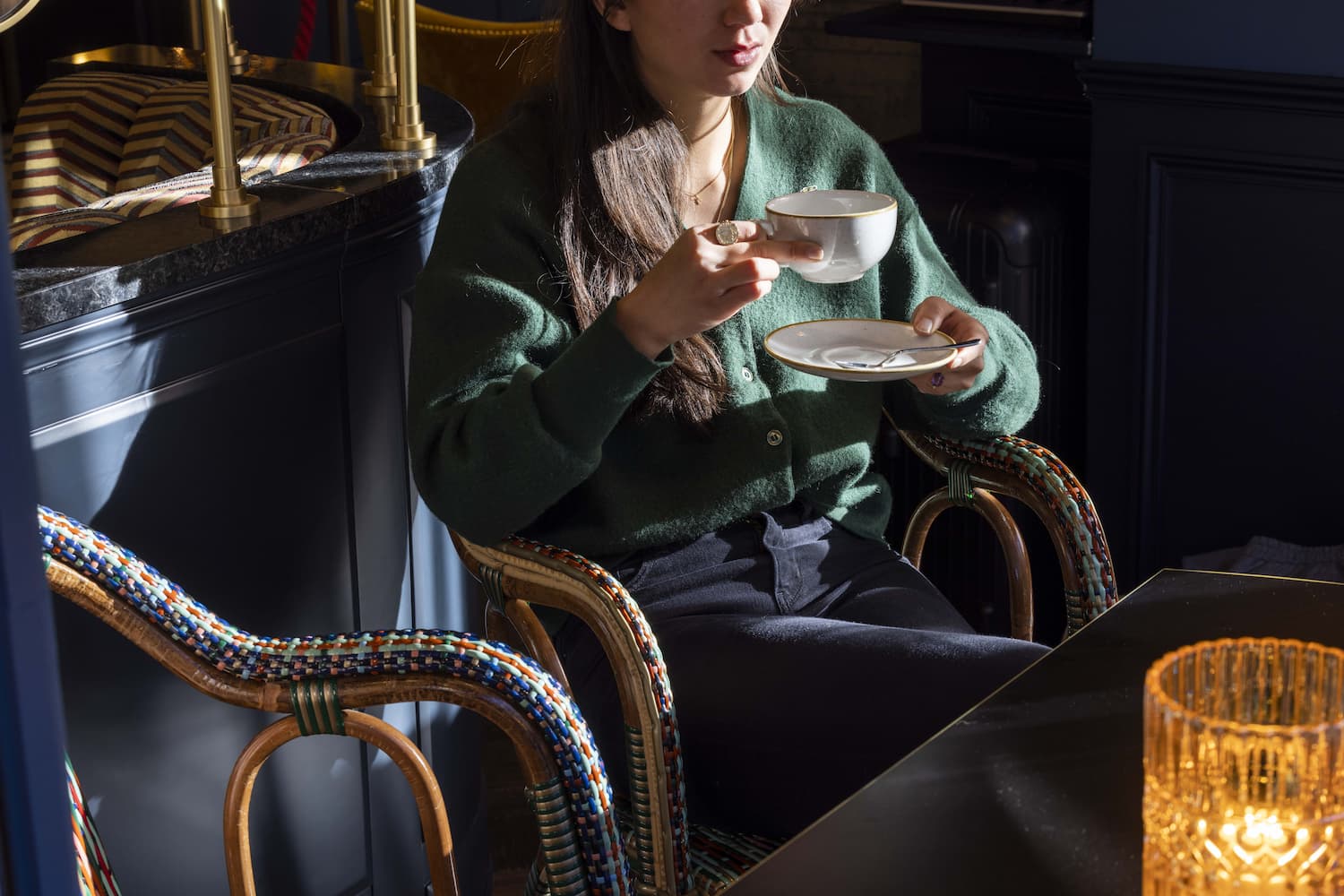 femme dégustant un café sans une chaise ennuyant rotin colorée - salon de thé sympa à Paris 6 au WELCOME HOTEL paris