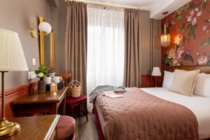 welcome hotel rive gauche paris - plan large d'une chambre single supérieure avec le lit, les rideau, la grande fenêtre, le bureau et la commode en bois