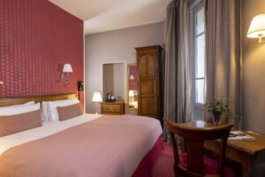 Chambre avec lit king size, bureau et fenêtre au Welcome hôtel Paris - Hiver à Paris