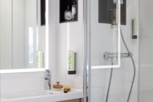 welcome hotel rive gauche paris : salle d'eau avec miroir lumineux,douche, corniche, brosse à cheveux