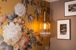 hotel chambre double paris : décoration, tissu jaune fleuri, applique allumé, photos de paris en noir et blanc accrochées au mur - WELCOME HOTEL paris