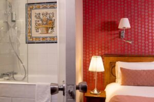 room with bed, red fabric and bathroom at welcome hotel Paris - the Paris international lingerie fair